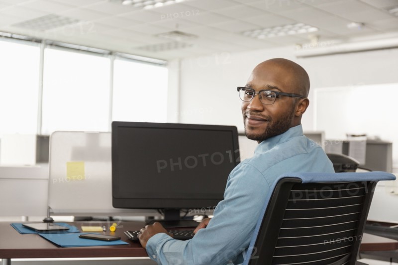 Smiling African American man using computer in office