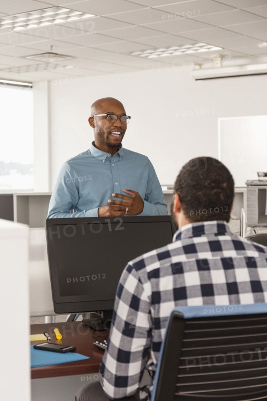 Men talking in office near computer