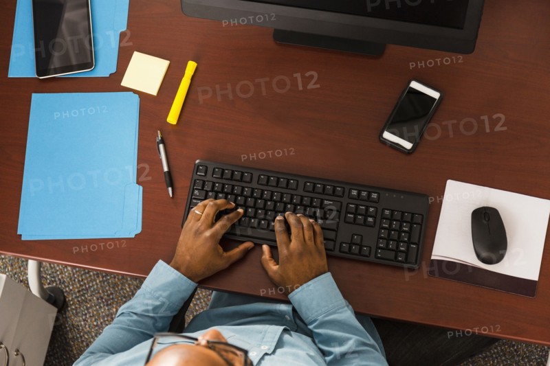 African American man typing on computer keyboard in office