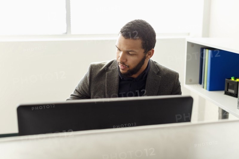 Mixed Race man using computer in office