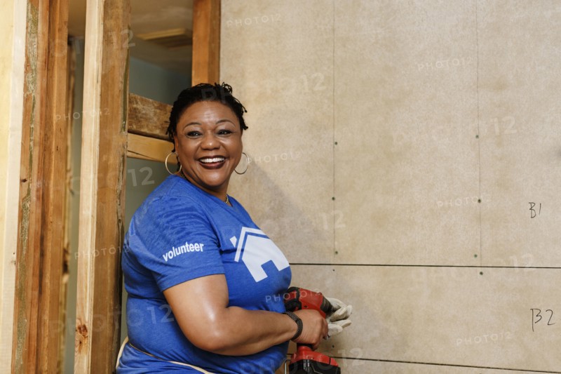 Portrait of smiling black woman holding drill