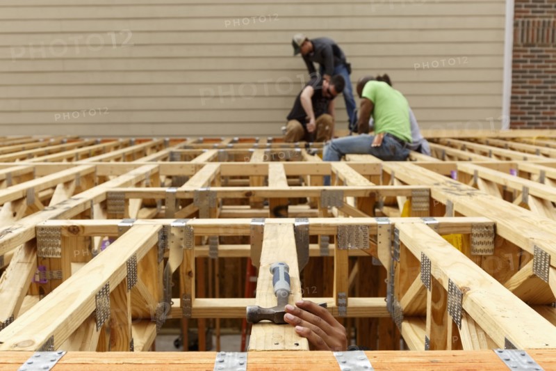 Hand reaching for hammer on the roof at construction site