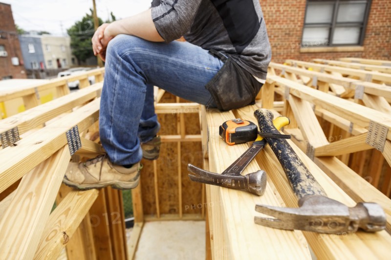 Caucasian man resting near hammer and tape measure