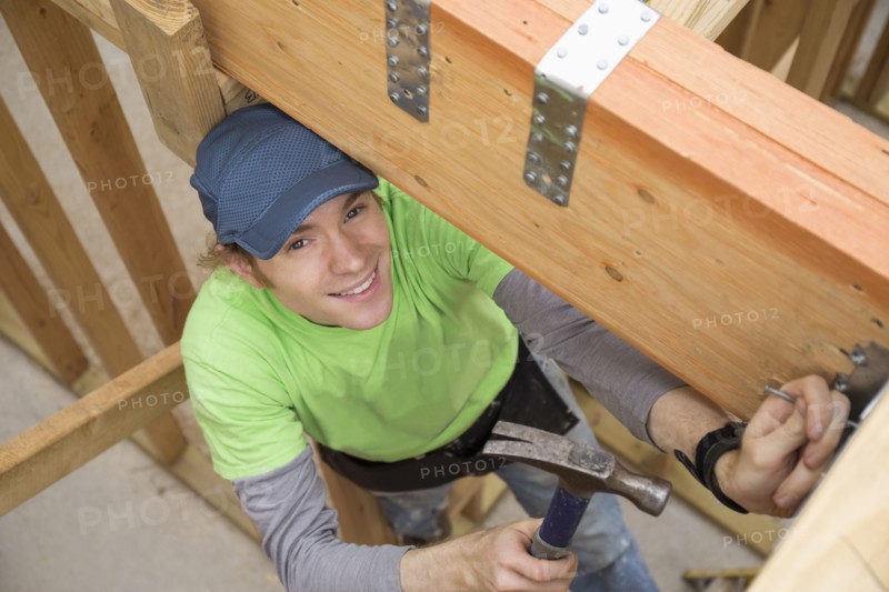 Caucasian man hammering nail at construction site