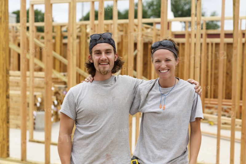 Caucasian man and woman posing at construction site