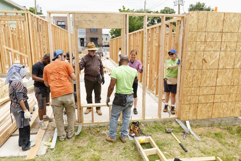 Volunteers holding wall at construction site