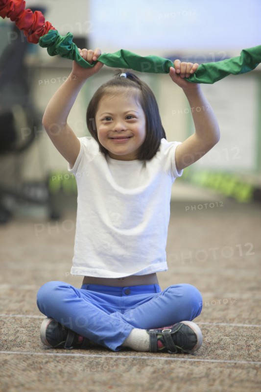 Mixed race Down syndrome girl playing with rope