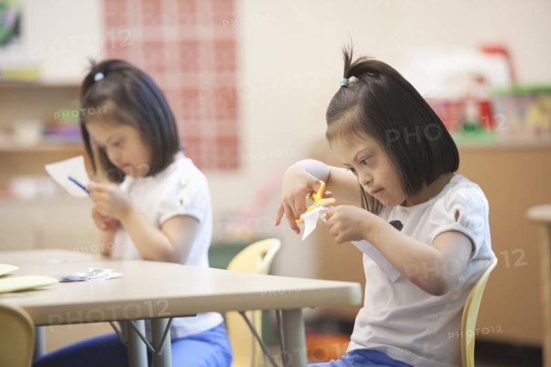 Mixed race students with Down syndrome in classroom