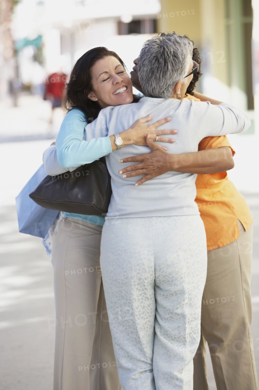Three women hugging outdoors