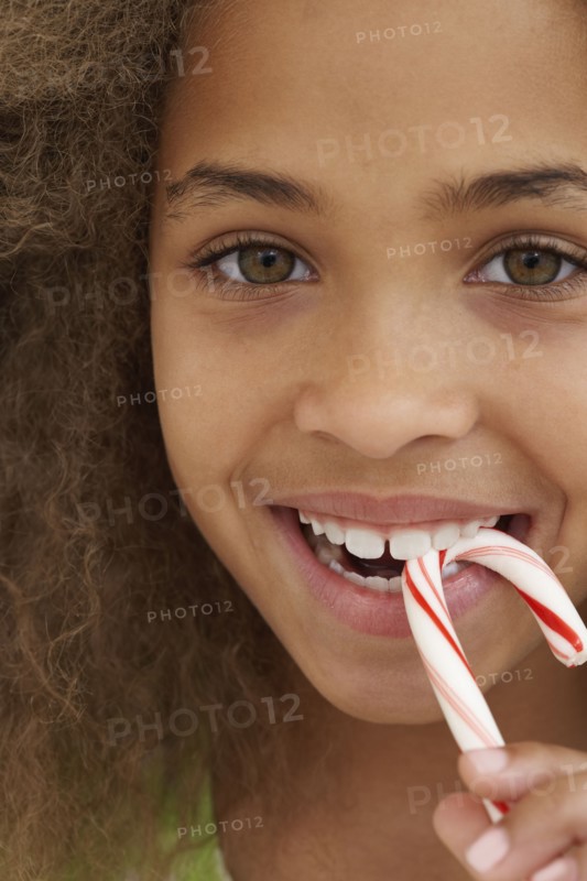 Close up of African American girl eating candy cane