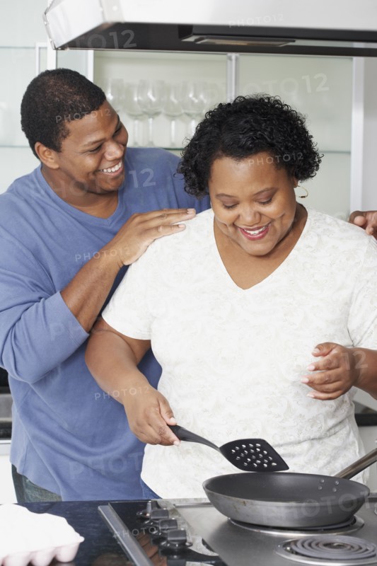 African couple cooking in kitchen