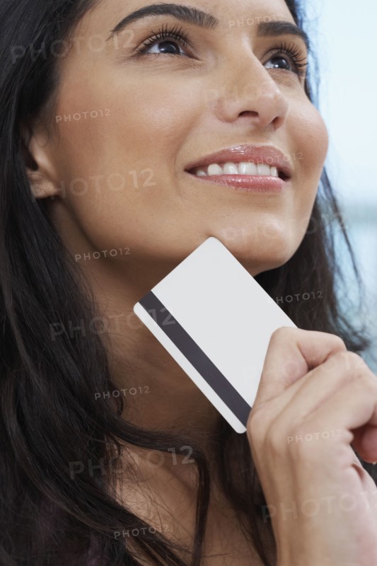 Close up of Hispanic woman holding credit card