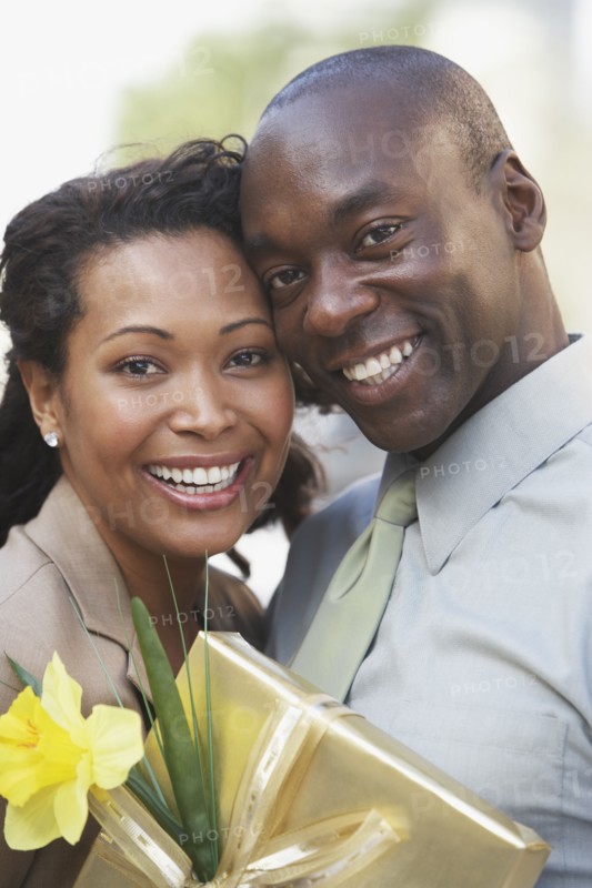 African couple hugging and holding gift
