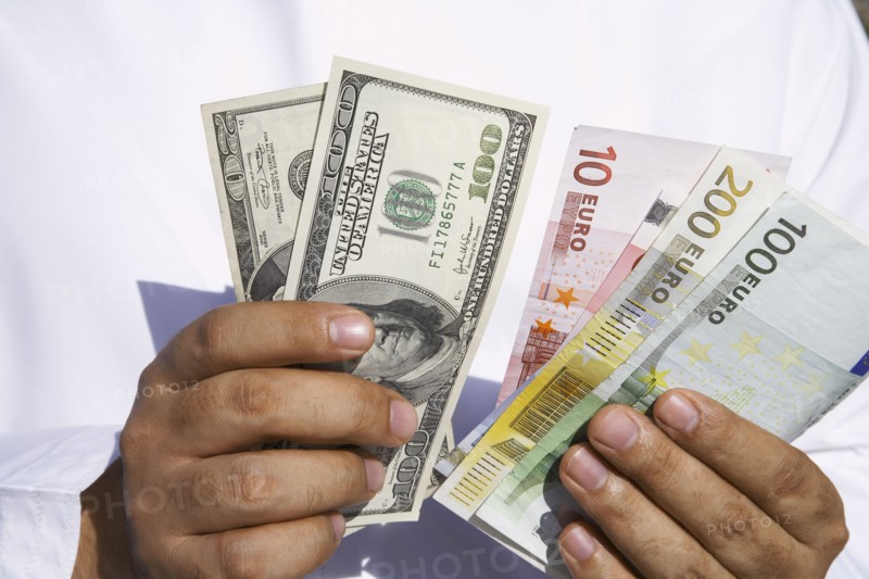 Close up of Arab man holding dollars and euros