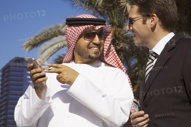 Multi-ethnic businessmen holding cell phones