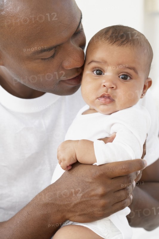 African father hugging baby daughter