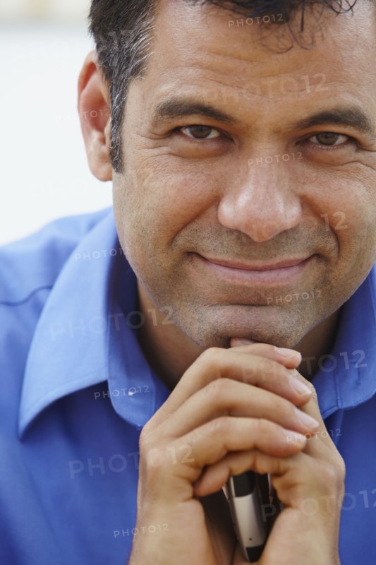 Close up of Hispanic businessman holding cell phone