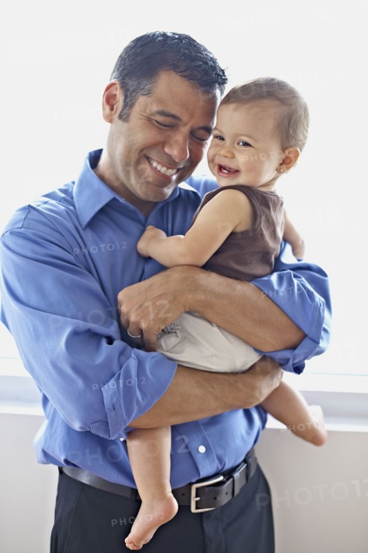 Hispanic father holding daughter