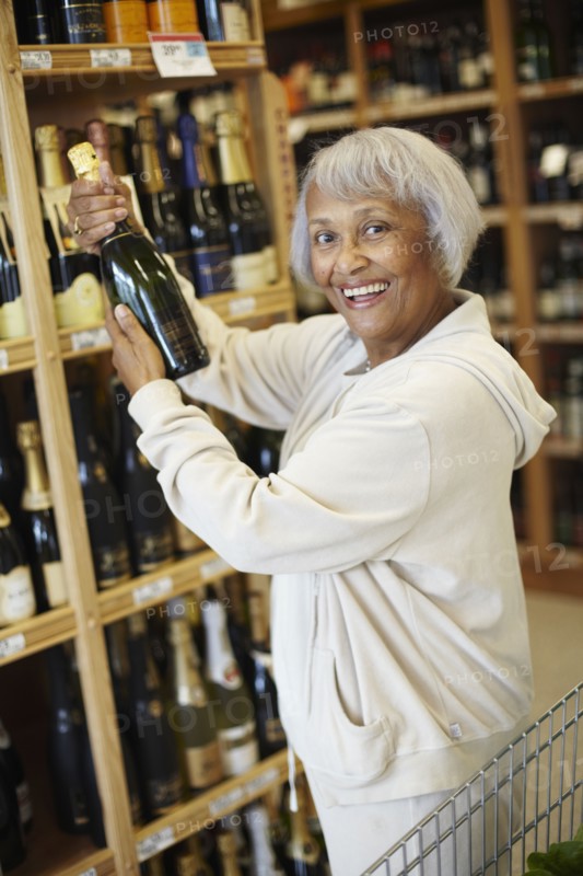 Senior African American woman buying champagne