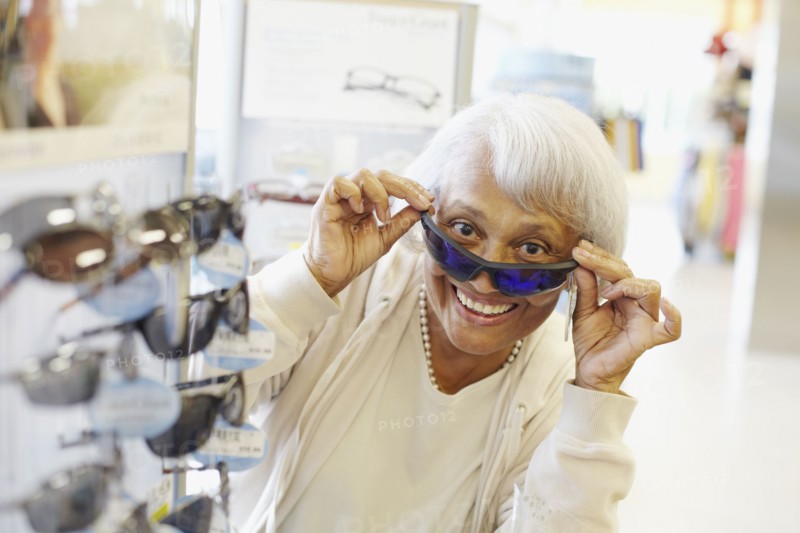Senior African American woman trying on sunglasses