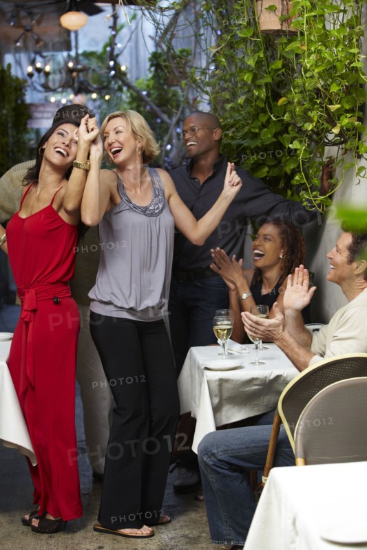 Friends dancing on restaurant patio