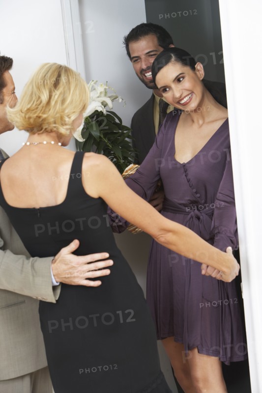 Friends greeting couple arriving for party