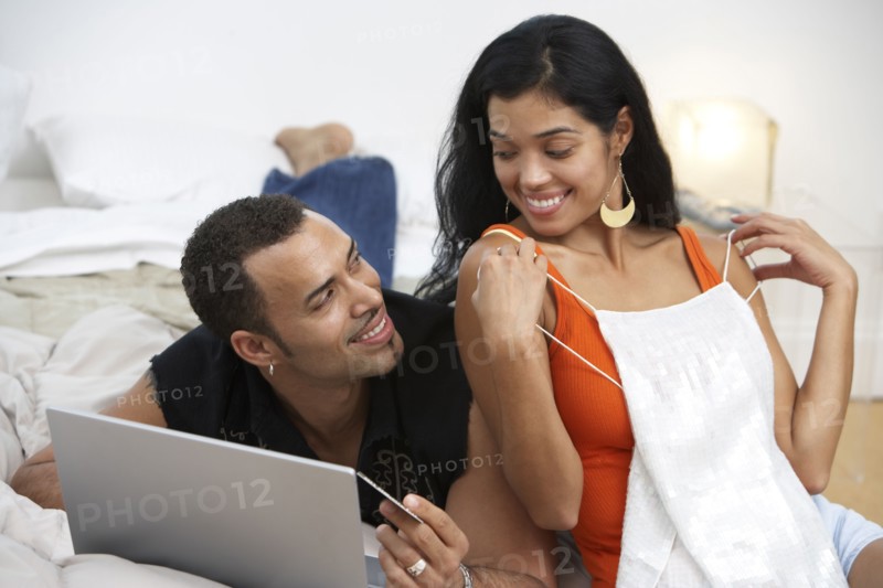 Hispanic woman showing lingerie to husband