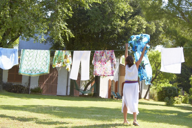 Caucasian woman hanging laundry on clothes line