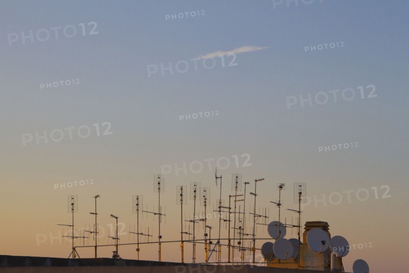 Silhouette of television antennas on rooftop