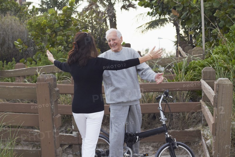 Caucasian woman hugging man on bicycle
