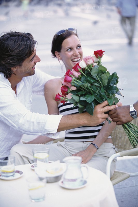 Man buying flowers for girlfriend at sidewalk cafe