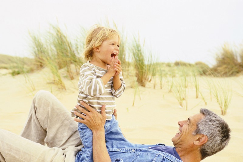 Caucasian father and son playing on beach
