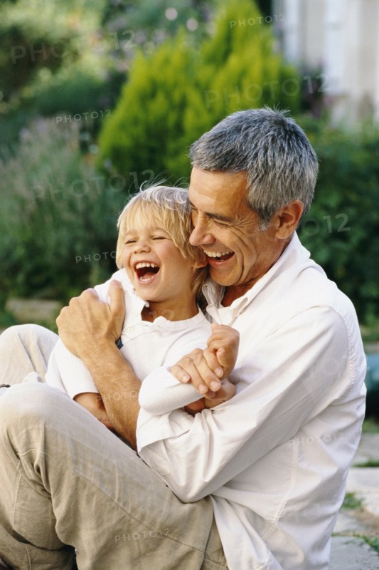 Caucasian father and son hugging outdoors