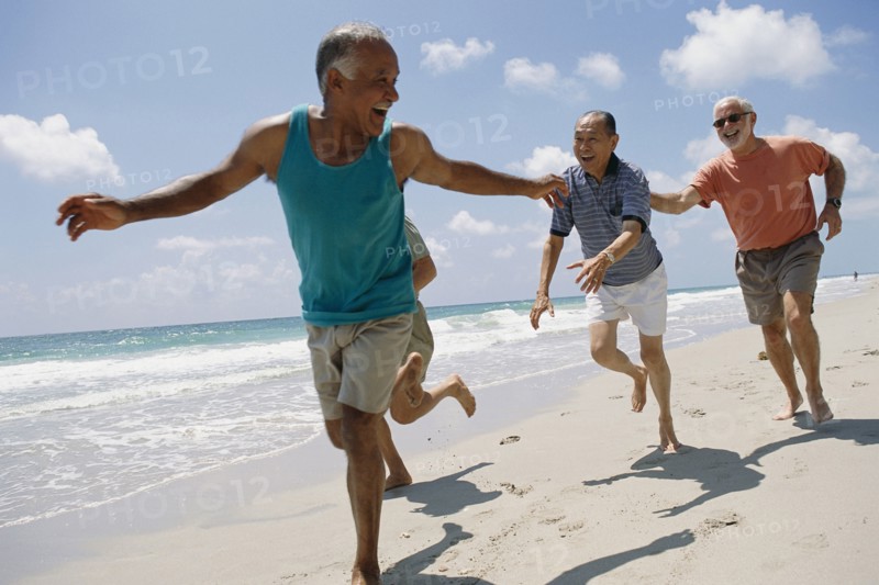 Senior friends jogging on beach