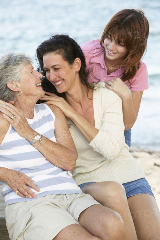 Three generations of women smiling outdoors