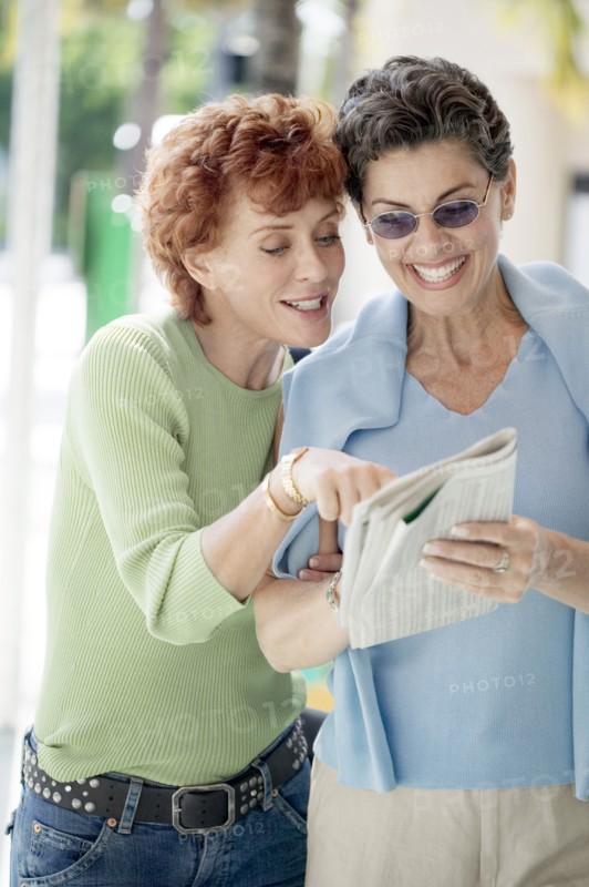 Senior women reading newspaper together