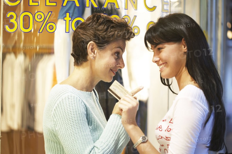 Women window shopping together on city street