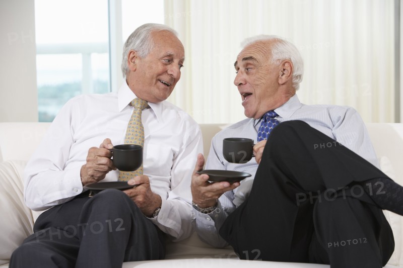 Senior businessmen having coffee on sofa
