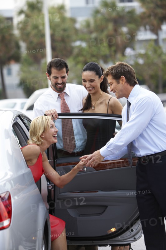 Man helping girlfriend out of car