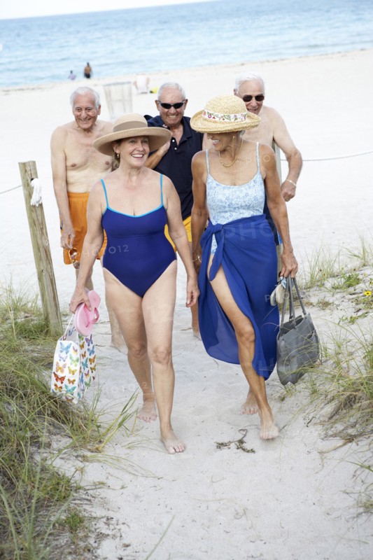 Senior friends walking on beach
