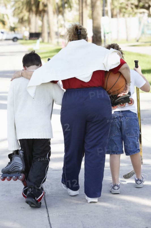 Mother and children walking on suburban street