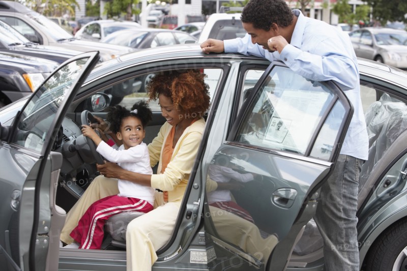 Black family admiring new car