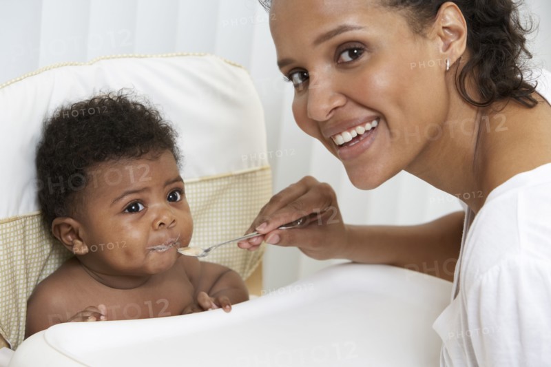 Mother feeding baby in high chair
