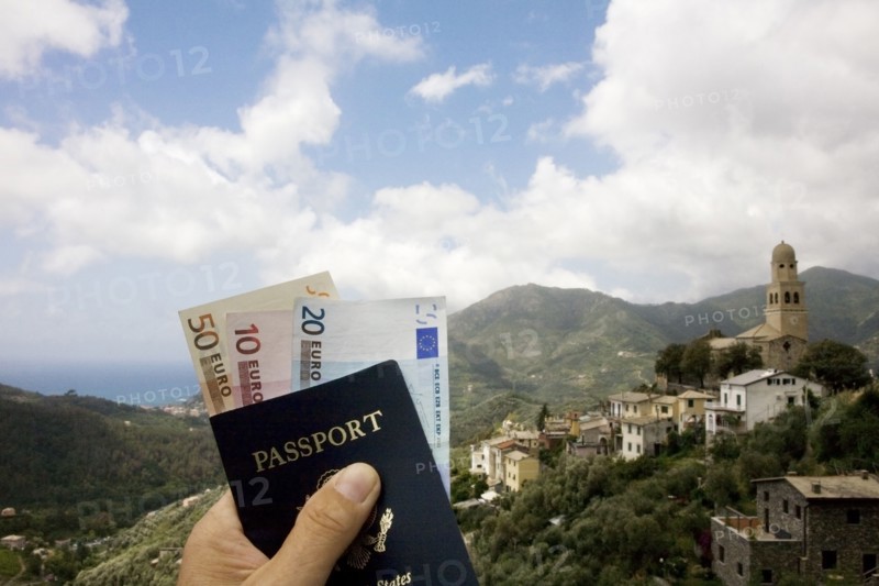 Passport and Euros overlooking rural landscape