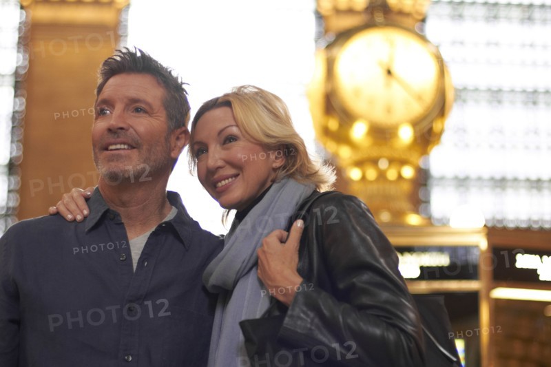 Caucasian couple hugging in Grand Central Station