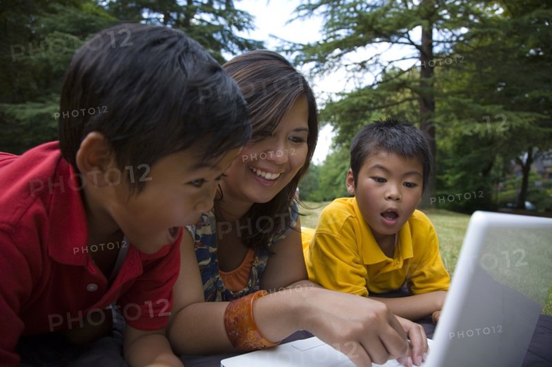 Asian mother showing sons laptop