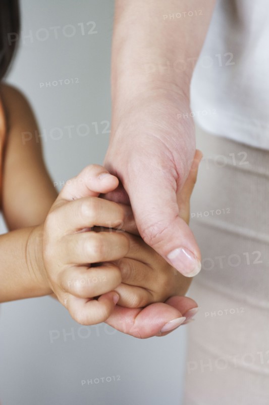 Chinese woman holding daughter's hand