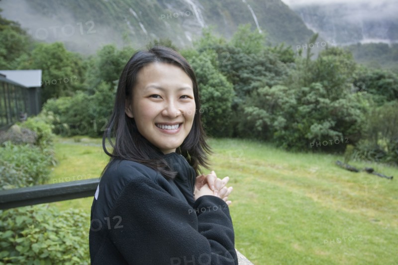 Chinese woman standing on balcony in remote area