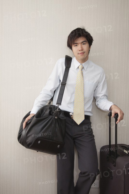 Chinese businessman standing with luggage