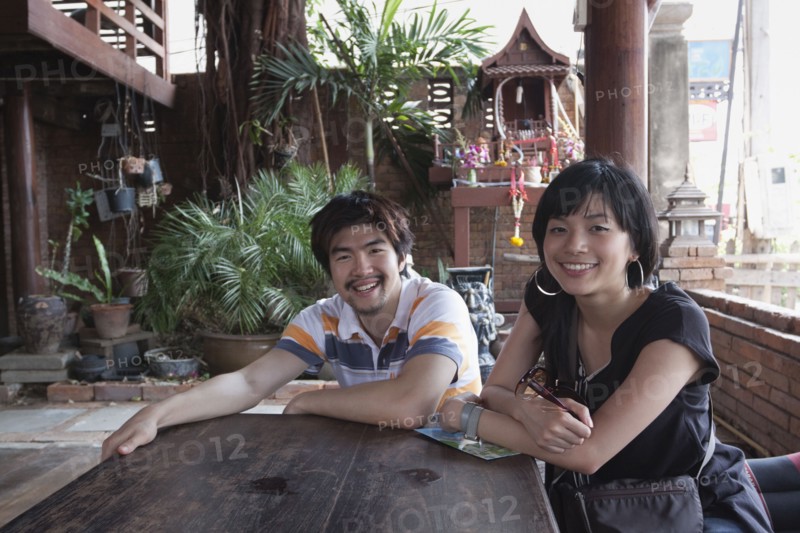 Asian couple sitting at patio table